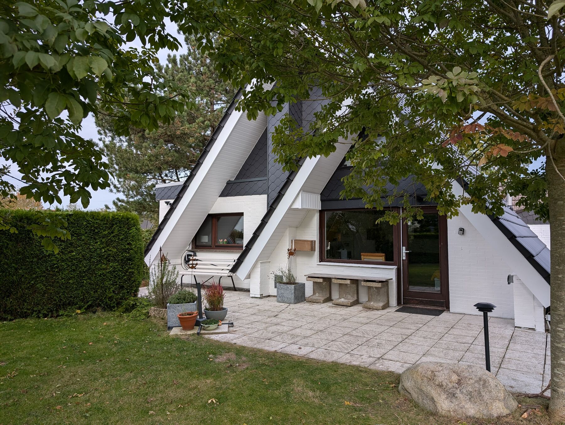 Das Nurdachhaus Achtern Diek 47 mit Terrasse und Garten im Sonnenschein