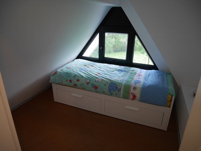 Schlafzimmer unterm Giebel mit dreieckigem Fenster