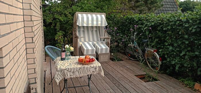Terrasse hinterm Haus mit Strandkorb